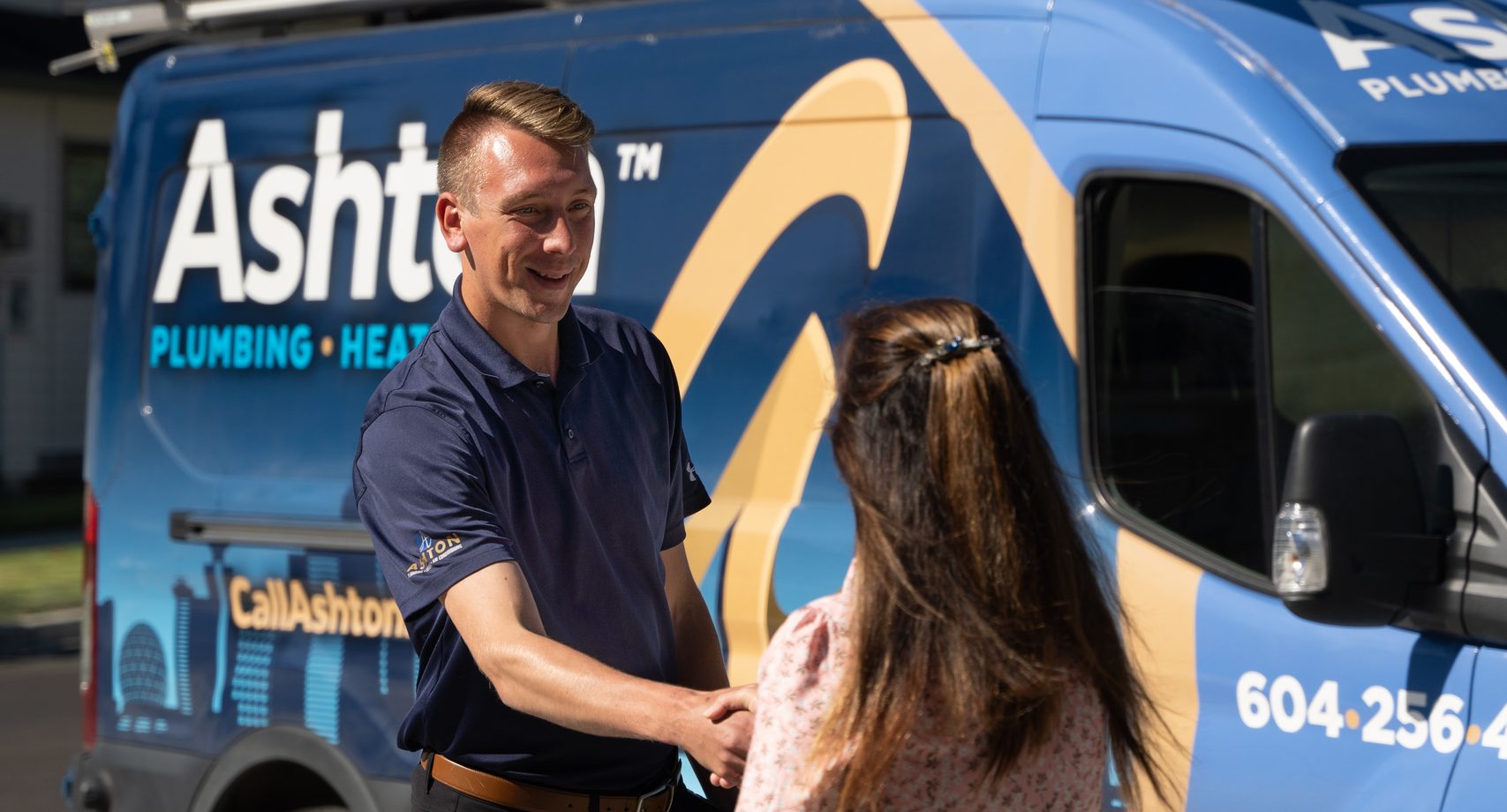 Ashton technician shaking hands with a customer beside an Ashton service van