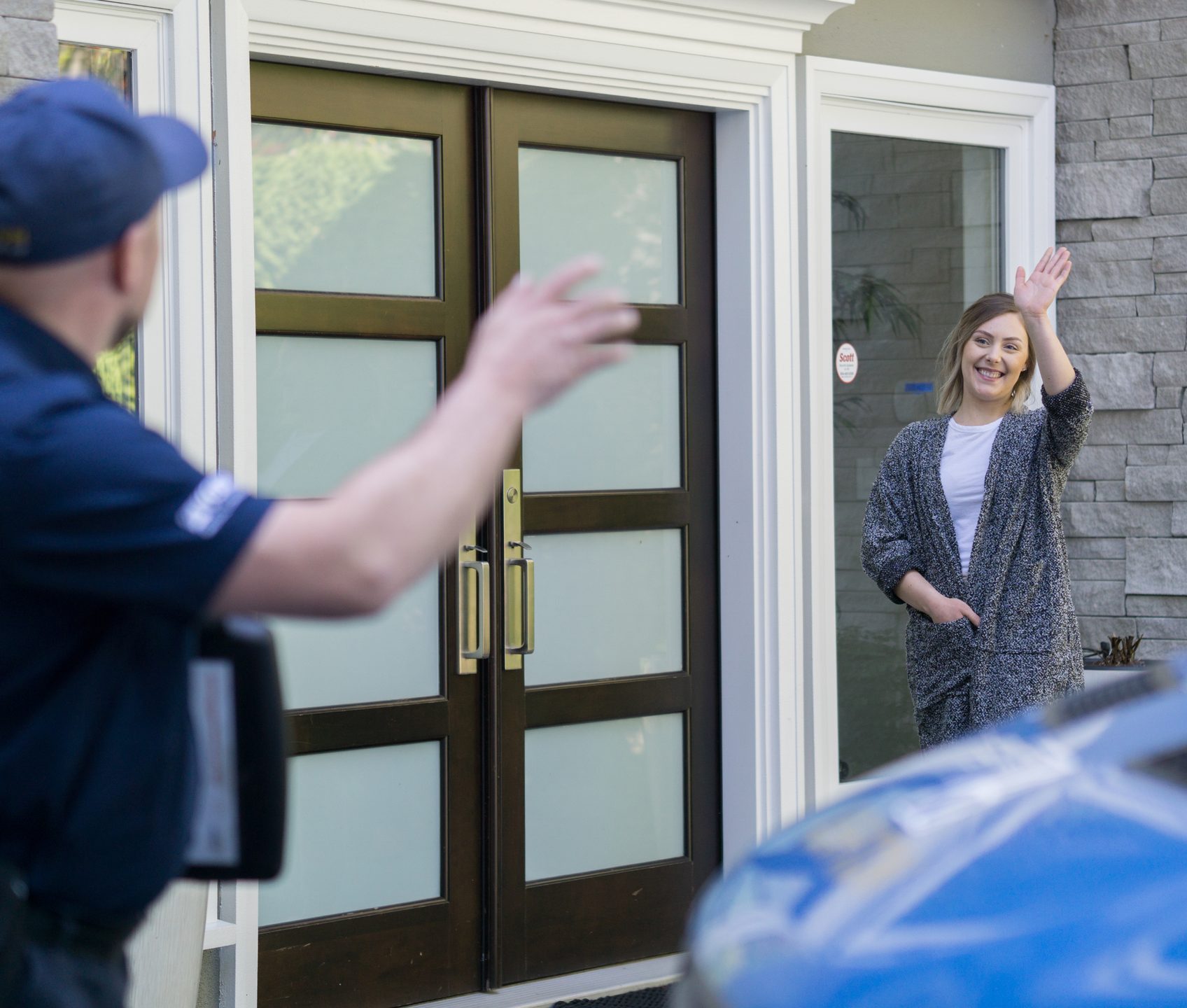 Homeowner waving hello to an arriving Ashton technician