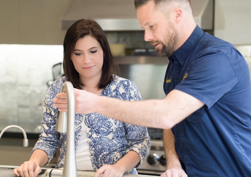 Ashton technician showing a homeowner a new kitchen faucet