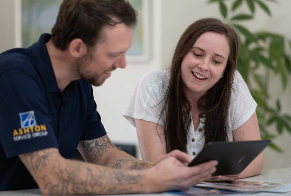 Ashton technician showing a homeowner details on a tablet