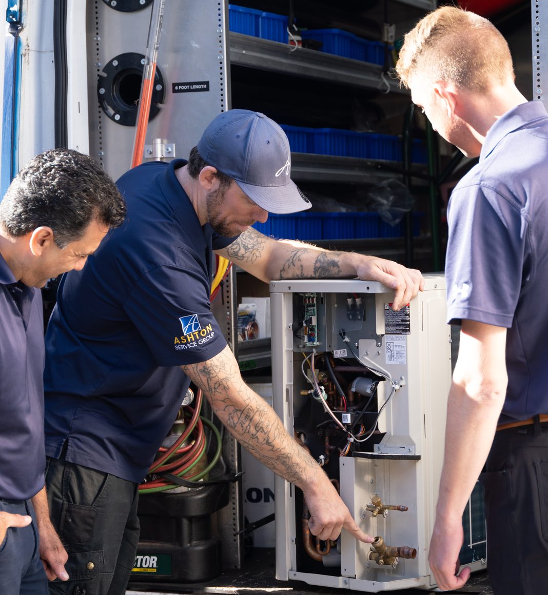 Ashton technicians working together on a heat pump unit