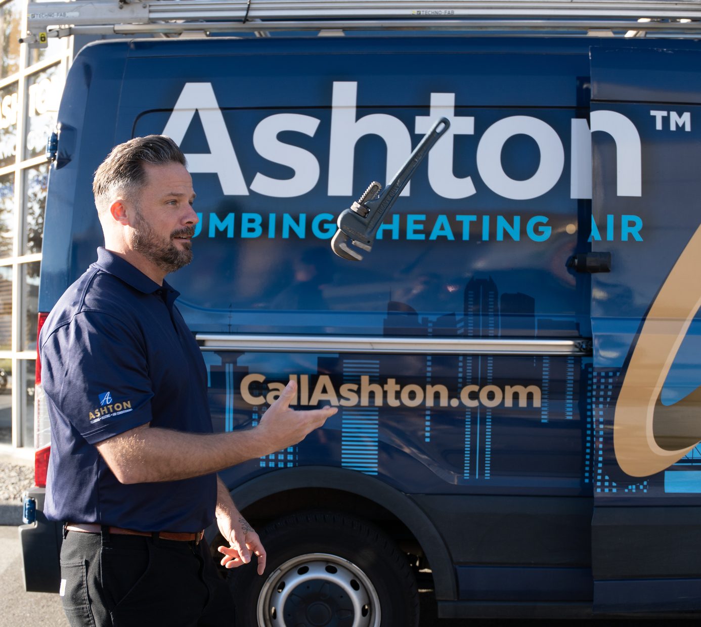 Ashton plumber standing beside an Ashton service van